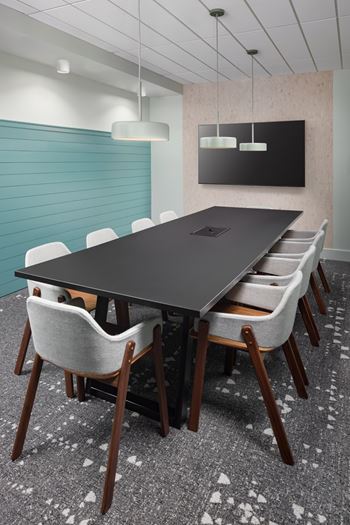 A conference room with a long table and chairs.